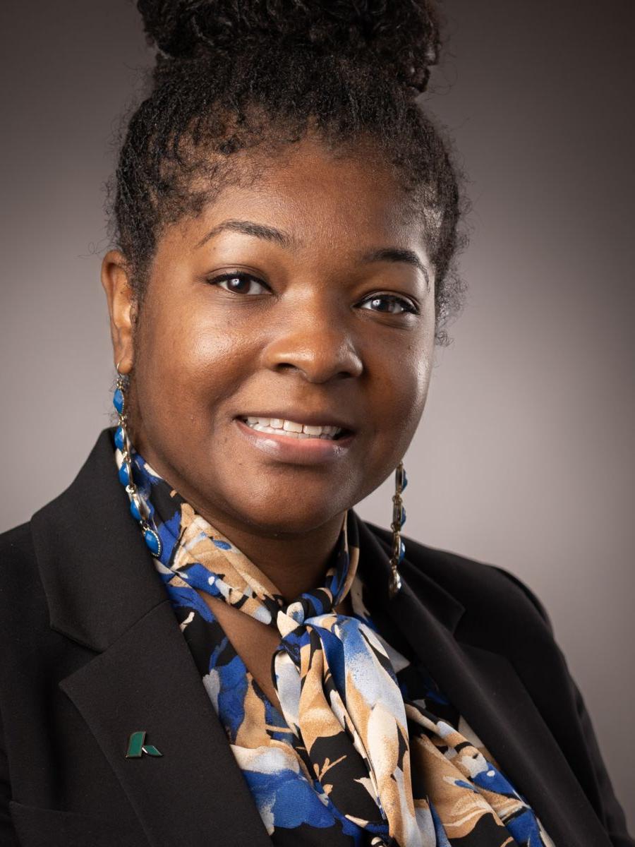 Ms. Aherial Polite, Dean for Arts and Sciences, smiles wearing a multi-colored dress top with a black dress jacket.